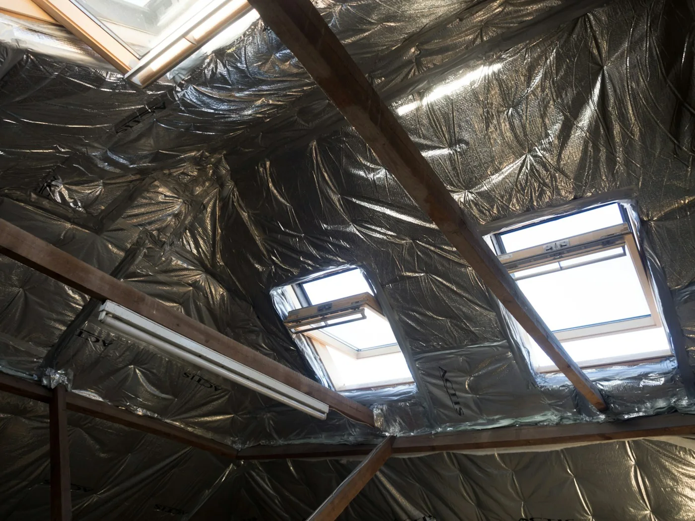 Technician in protective suit cleaning rodent-contaminated attic insulation